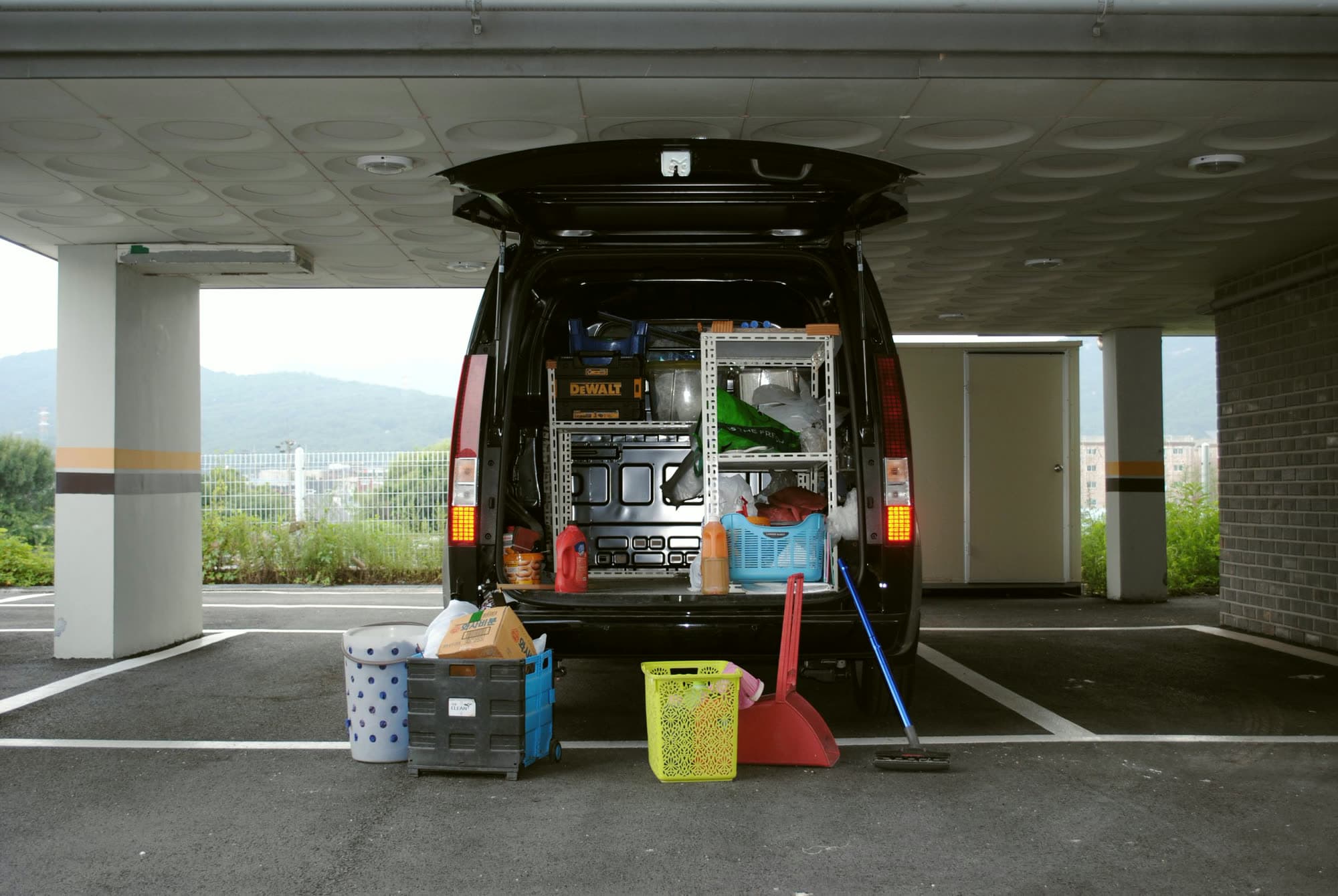 A service van with its back doors open and shelves of equipment inside.