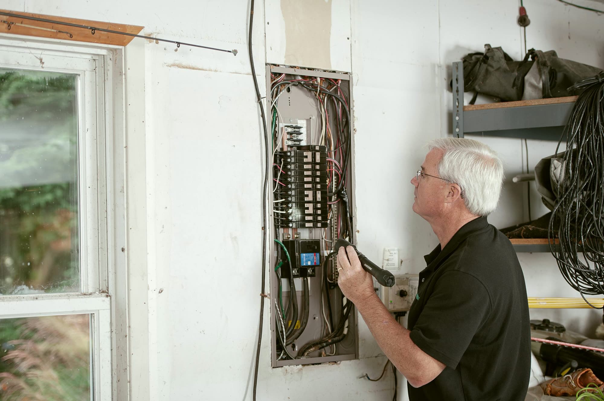 An electrician checking the fuse box in a home.